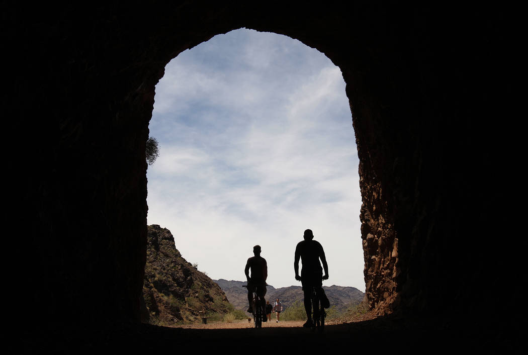 Riders bicycle through a tunnel along the Historic Railroad Trail near Lake Mead. (John Locher/ ...
