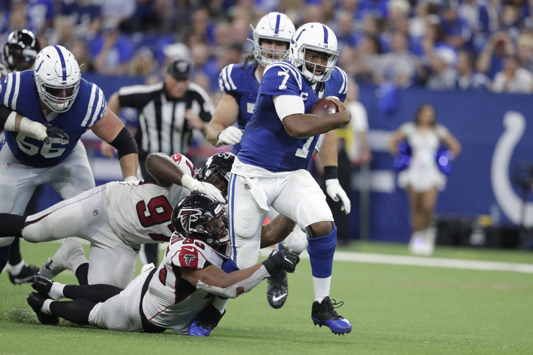 Indianapolis Colts quarterback Jacoby Brissett (7) runs out of the tackle of Atlanta Falcons de ...