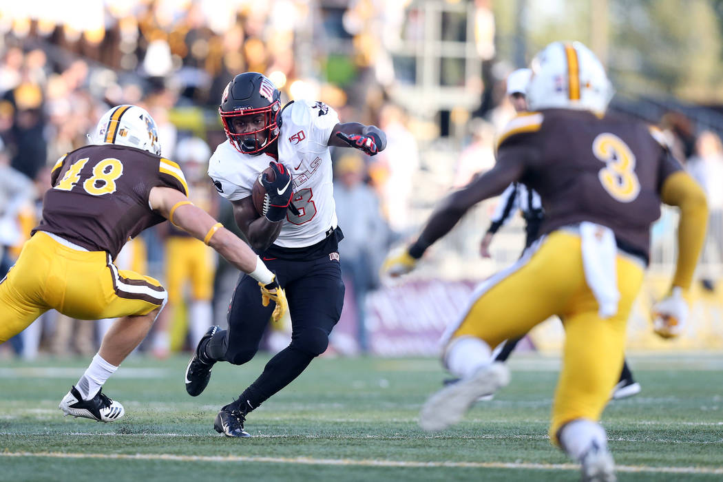 UNLV running back Charles Williams attempts to juke past University of Wyoming linebacker Chad ...