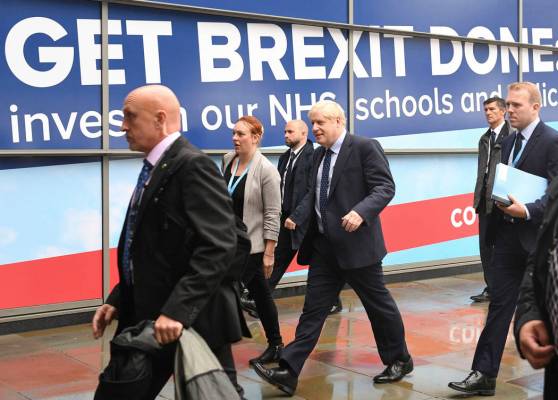 Britain's Prime Minister Boris Johnson, centre, arrives at the Conservative Party Conference in ...