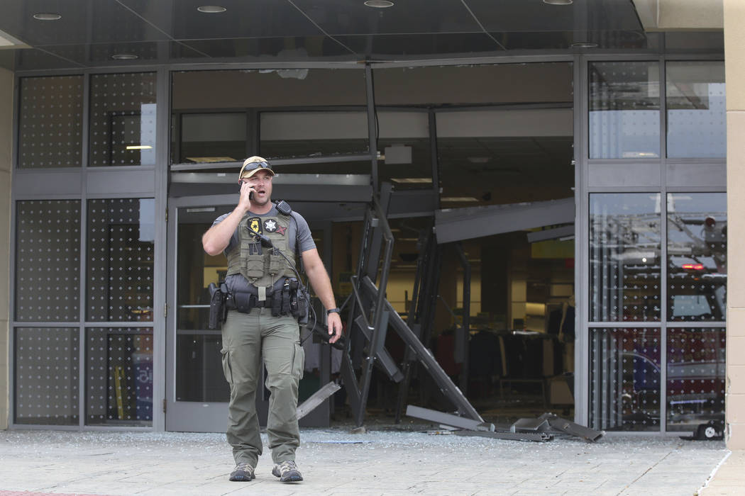 A state police officer stands outside of a Woodfield Mall entrance after a man drove an SUV int ...