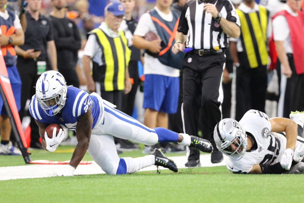 Indianapolis Colts running back Marlon Mack (25) sheds a tackle from Oakland Raiders free safet ...