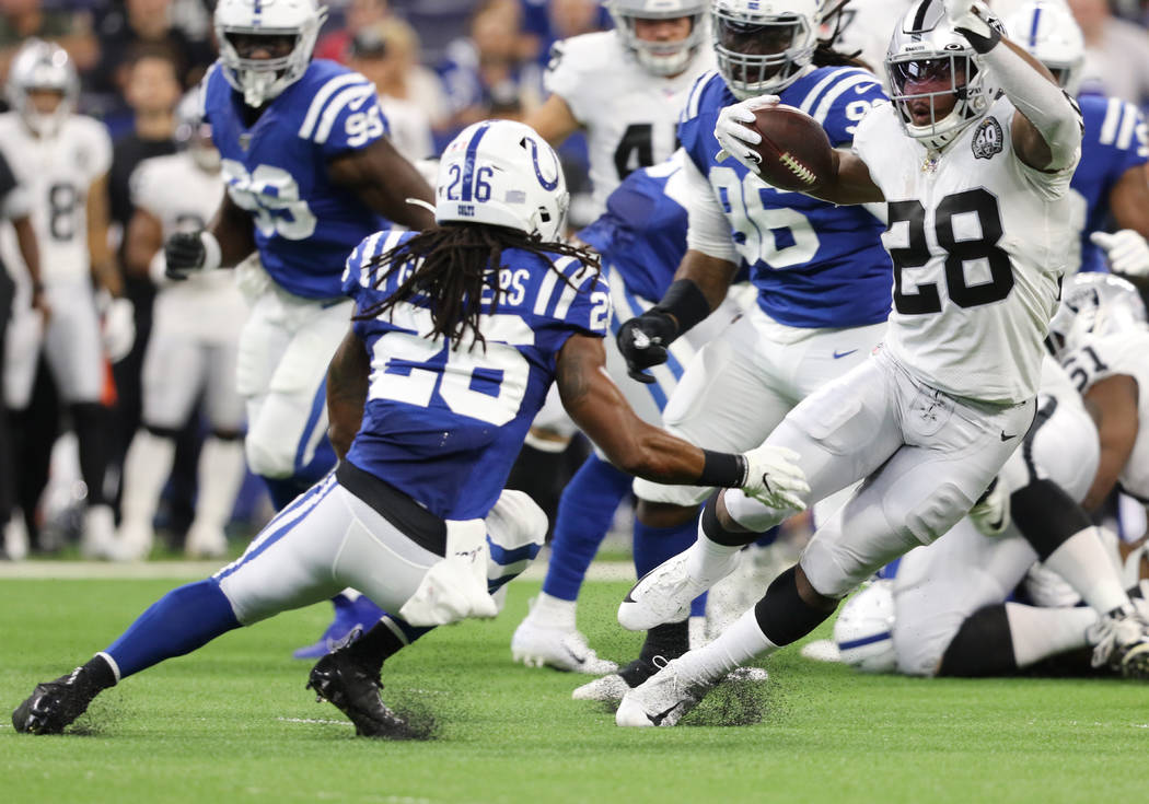 Oakland Raiders running back Josh Jacobs (28) runs past Indianapolis Colts strong safety Clayto ...