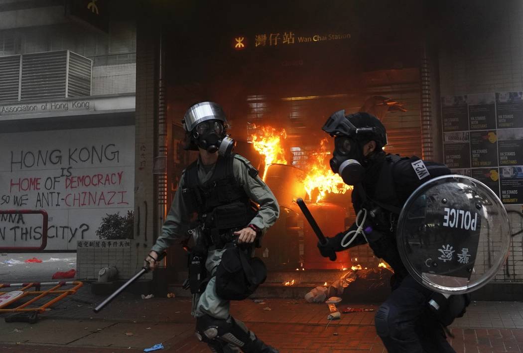 Riot police arrive after protestors vandalize in Hong Kong, Sunday, Sept. 29, 2019. Riot police ...