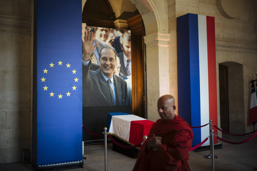 A monk walks past by the coffin of late French President Jacques Chirac, Sunday, Sept. 29, 2019 ...