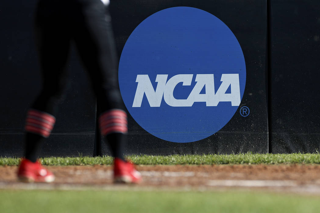 FILE - In this April 19, 2019, file photo, an athlete stands near a NCAA logo during a softball ...