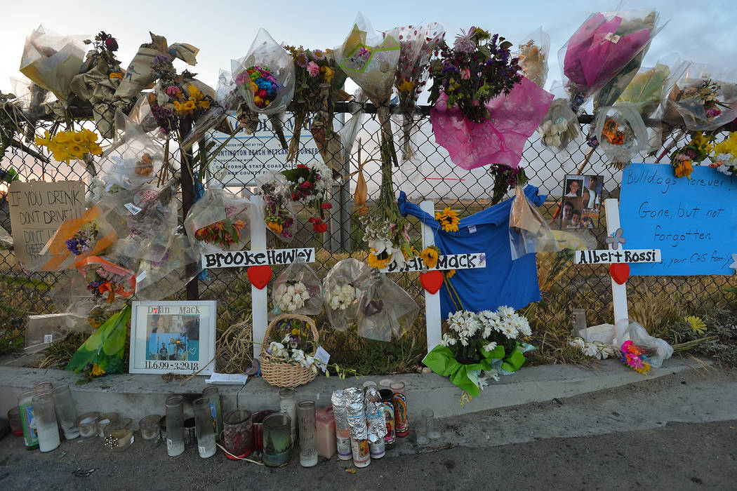 Flowers, photos, candles and signs are posted at the corner of Magnolia Street and Pacific Coas ...