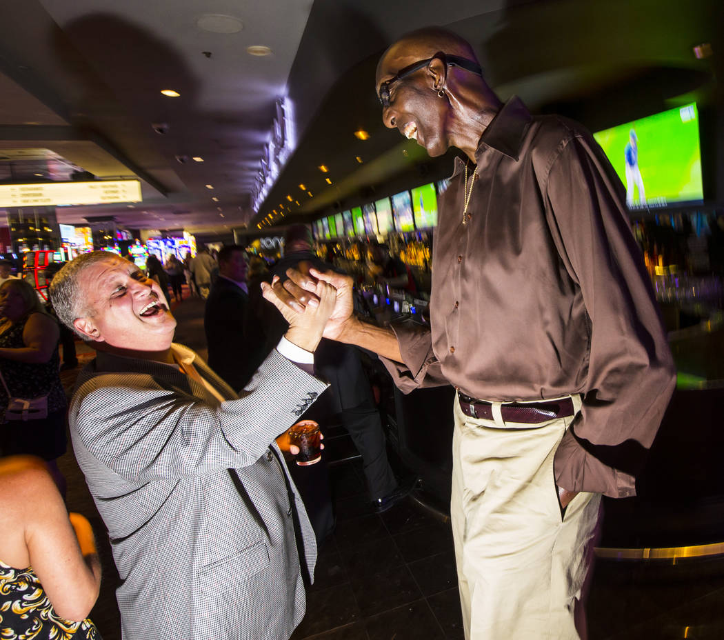 George Bell, who stands 7 feet 8 inches tall, talks with Derek Stevens, owner of The D Las Vega ...