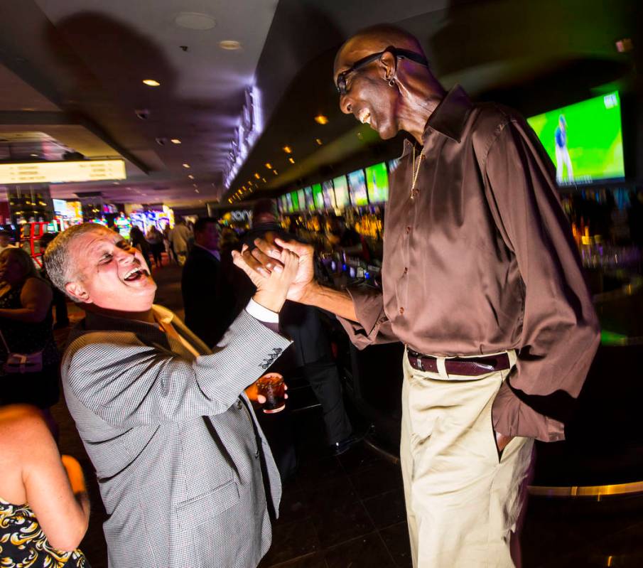 George Bell, who stands 7 feet 8 inches tall, talks with Derek Stevens, owner of The D Las Vega ...