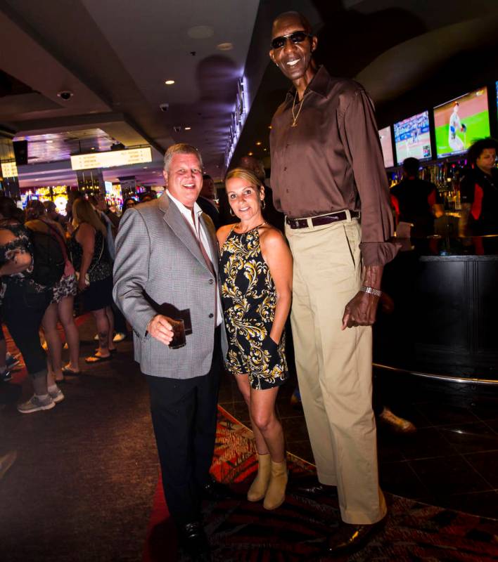 George Bell, who stands 7 feet 8 inches tall, poses for a portrait with Derek Stevens, owner of ...