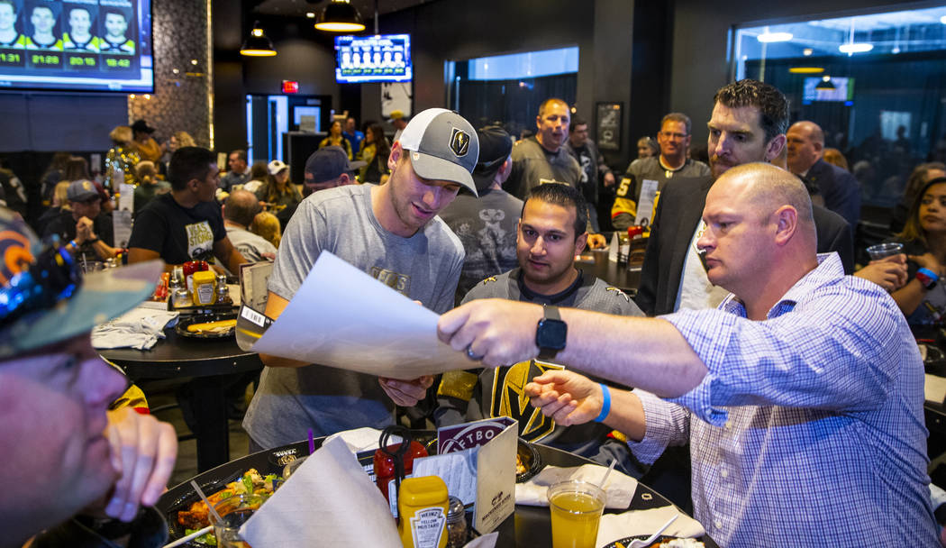 The Vegas Golden Knights Shea Theodore, center, signs an autograph during a meet and greet to h ...