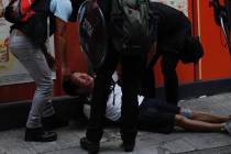 An injured anti-government protester is attended to by others during a clash with police in Hon ...
