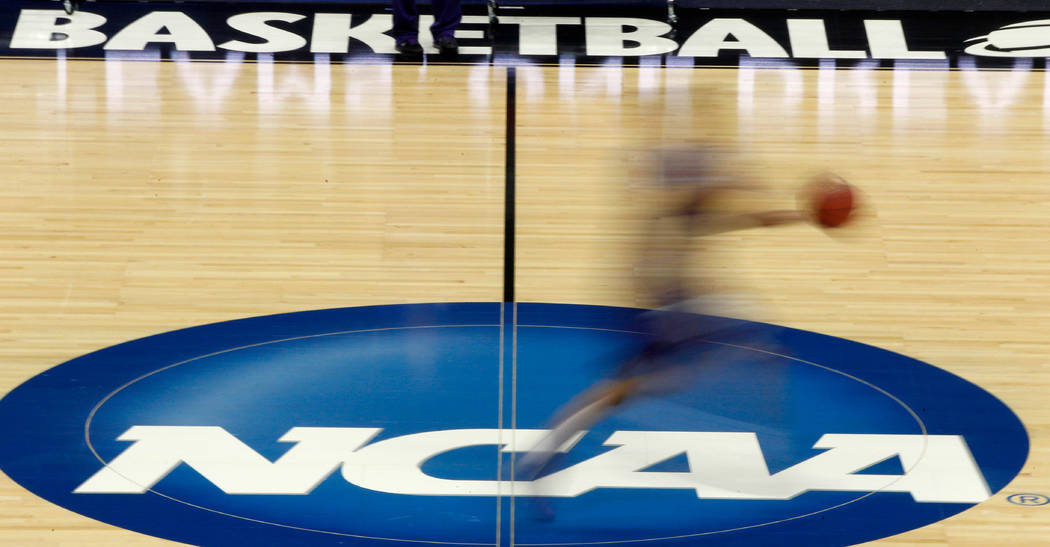 FILE - In this March 14, 2012, file photo, a player runs across the NCAA logo during practice a ...