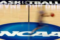FILE - In this March 14, 2012, file photo, a player runs across the NCAA logo during practice a ...