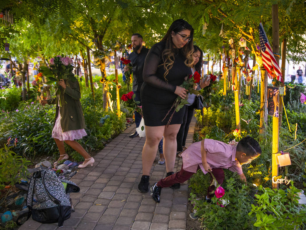 The King family lays flowers for each October 1st victim along the path of decorated trees at ...