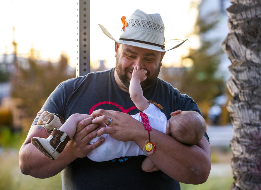 Oct. 1 survivor Gerald Crisp plays with his son Colby, 4-months-old, while visiting the Las Veg ...