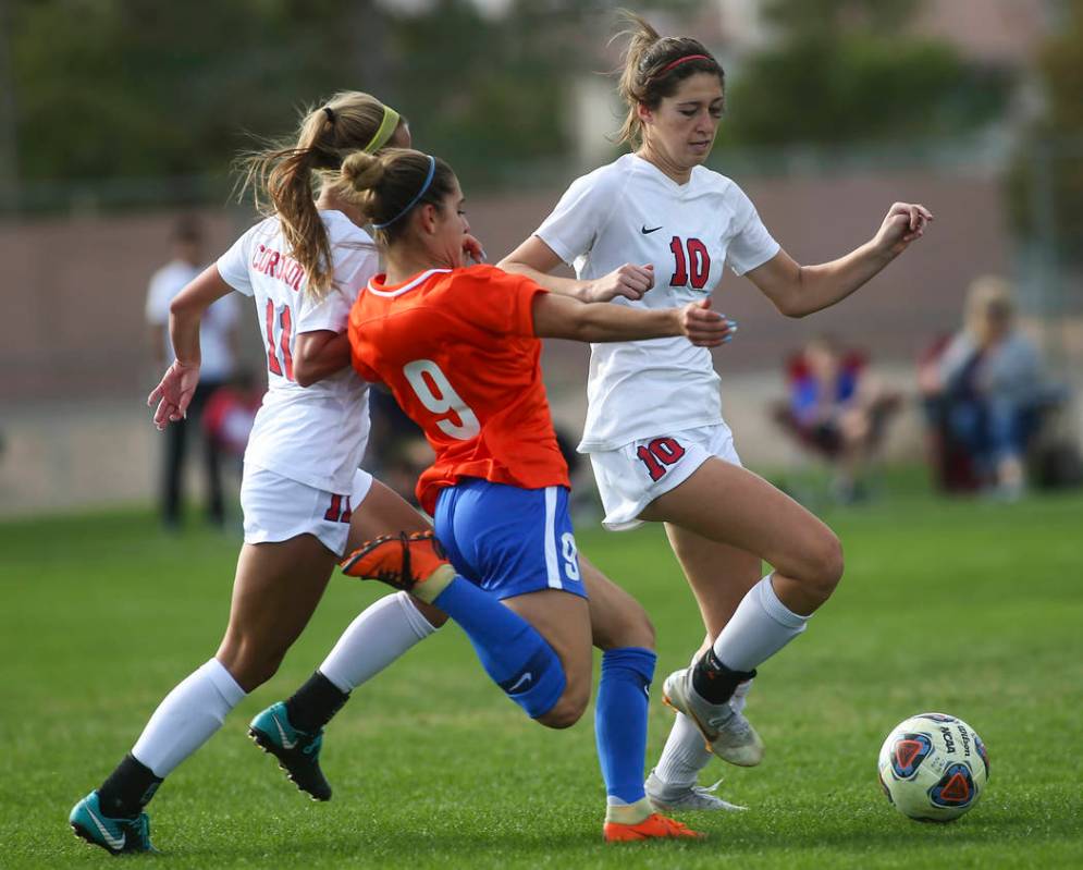 Bishop Gorman's Jaden Terrana (9) tries to get the ball from Coronado's Kaitlyn Kowalchuk (10) ...