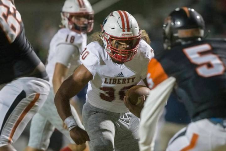 Liberty junior running back Zyrus Fiaseu (30) weaves through traffic past Chaparral senior corn ...