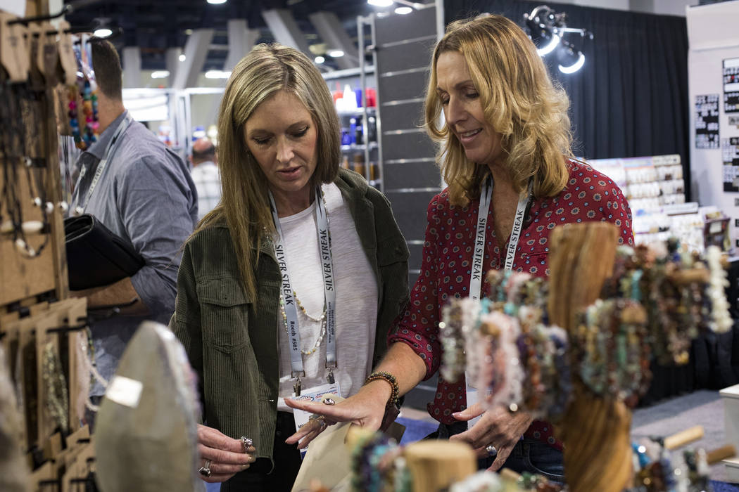 Lynn Mitchell, left, of Cape Cod, looks at gem stones and jewelry for sale next to colleague Ka ...