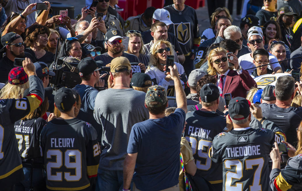 Vegas Golden Knights center William Karlsson does a "selfie" by fans while walking th ...