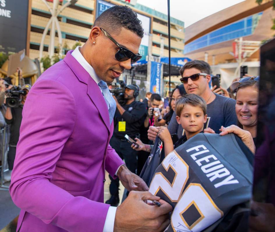 Vegas Golden Knights right wing Ryan Reaves signs an autograph for a fan while walking the gold ...