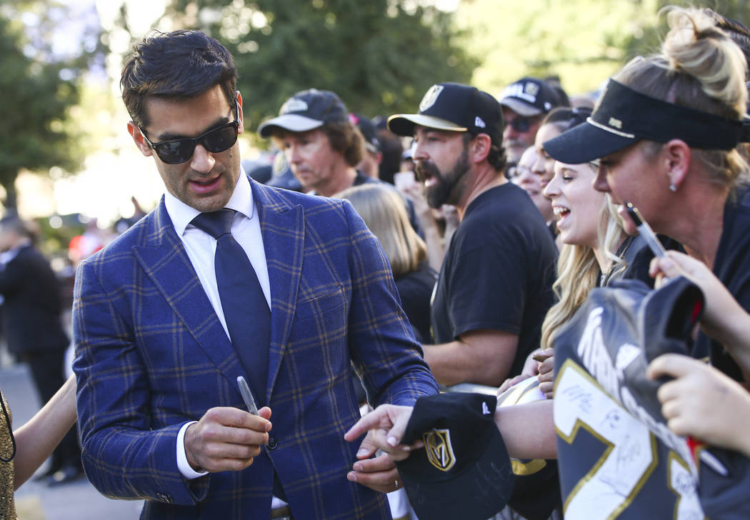 Golden Knights' Max Pacioretty signs autographs on the gold carpet after arriving for the NHL s ...