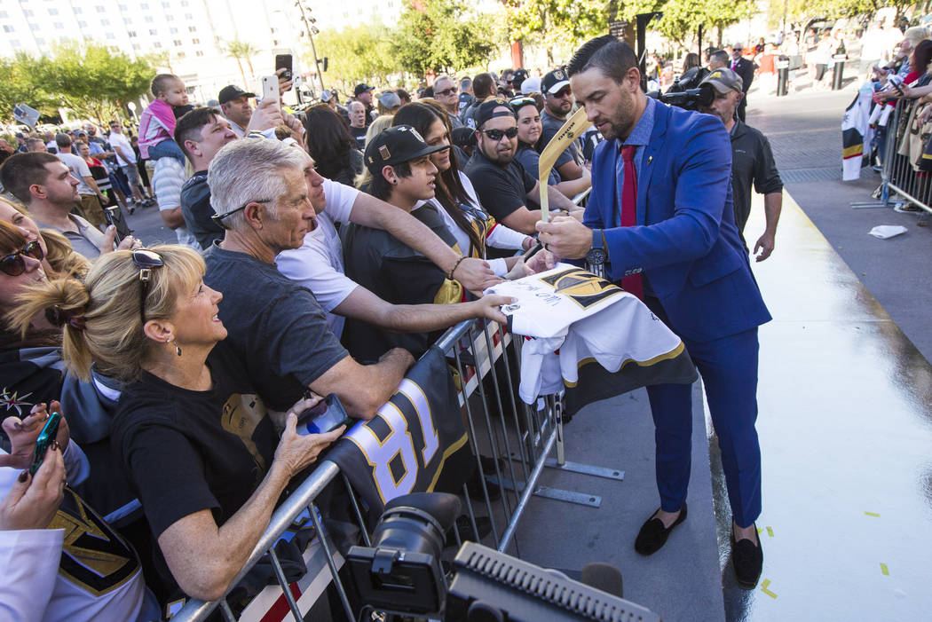 Golden Knights' Deryk Engelland signs autographs on the gold carpet after arriving for the NHL ...