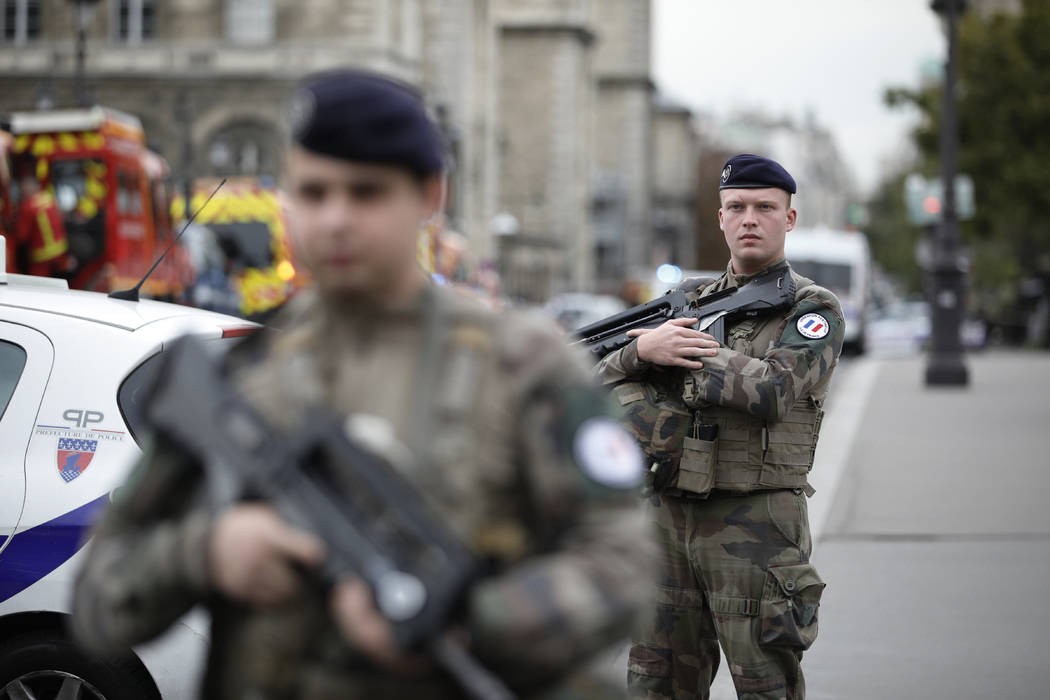 Armed soldiers patrol after an incident at the police headquarters in Paris, Thursday, Oct. 3, ...