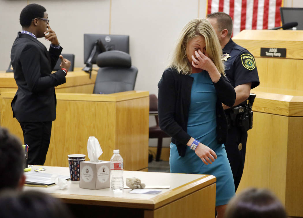 Former Dallas Police Officer Amber Guyger walks back to her desk after hugging victim Botham Je ...