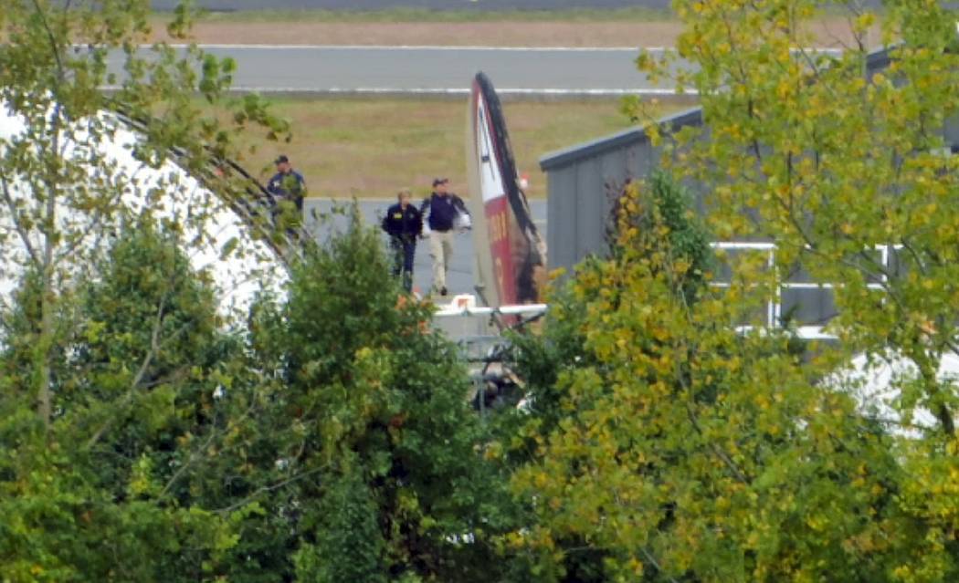 In this still image from video, members of the National Transportation Safety Board walk near t ...