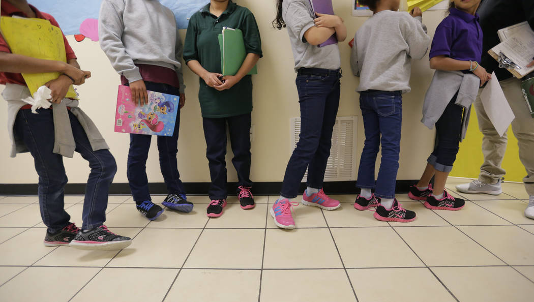 Migrant teens line up for a class at a "tender-age" facility for babies, children and ...