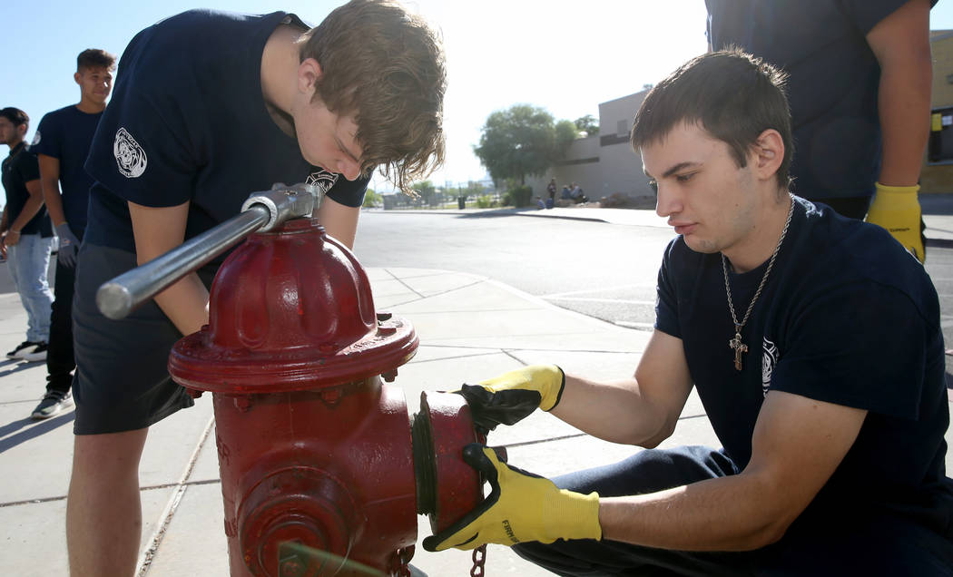 Bonanza High School Fire Science Academy students Charlie Stromoski, left, and Jacob Perez hook ...