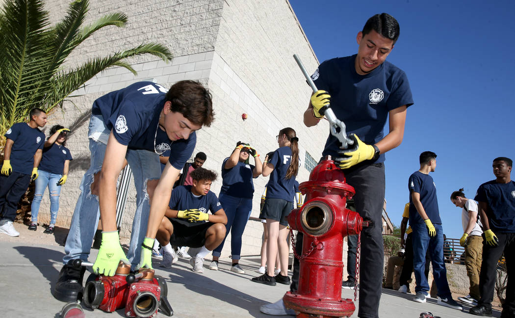 Bonanza High School Fire Science Academy seniors Jerry Galaviz, left, and Angel Corona hook a h ...