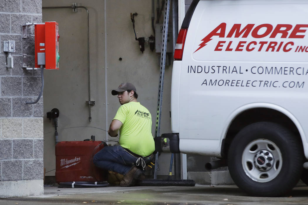 In a Wednesday, Oct. 2, 2019, photo, an electrician works at a car wash in North Andover, Mass. ...