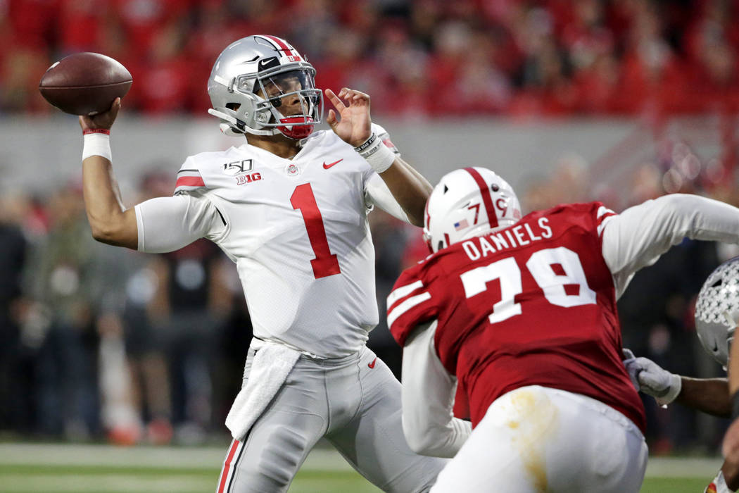 Ohio State quarterback Justin Fields (1) throws a pass as Nebraska defensive lineman Darrion Da ...