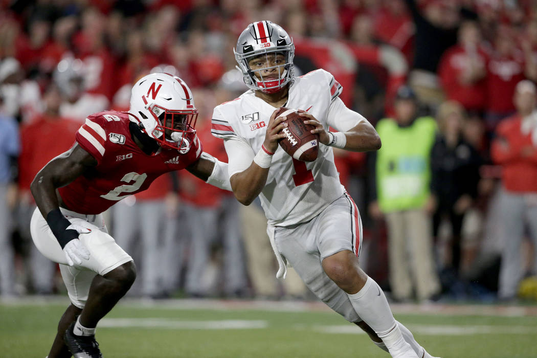 Ohio State quarterback Justin Fields (1) scrambles away from Nebraska linebacker Caleb Tannor ( ...