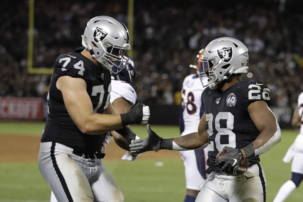 Oakland Raiders running back Josh Jacobs, right, is greeted by offensive tackle Kolton Miller ( ...