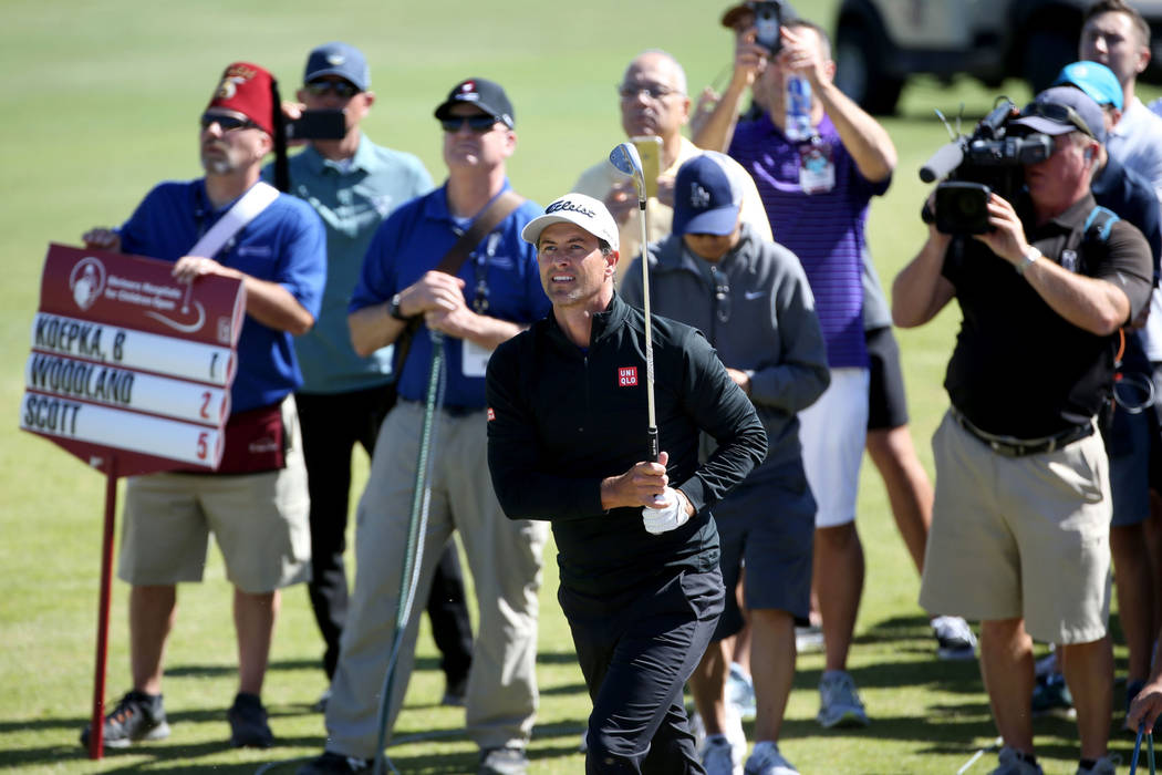 Adam Scott watches his tee shot from near the cart path after taking a penalty stroke the sixth ...