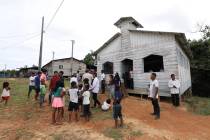 Residents gather outside the Catholic church of Novo Cruzador, Brazil, after attending a prayer ...