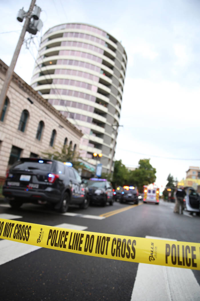 Police respond to a shooting at an apartment building, top rear, in Vancouver, Wash., Thursday, ...
