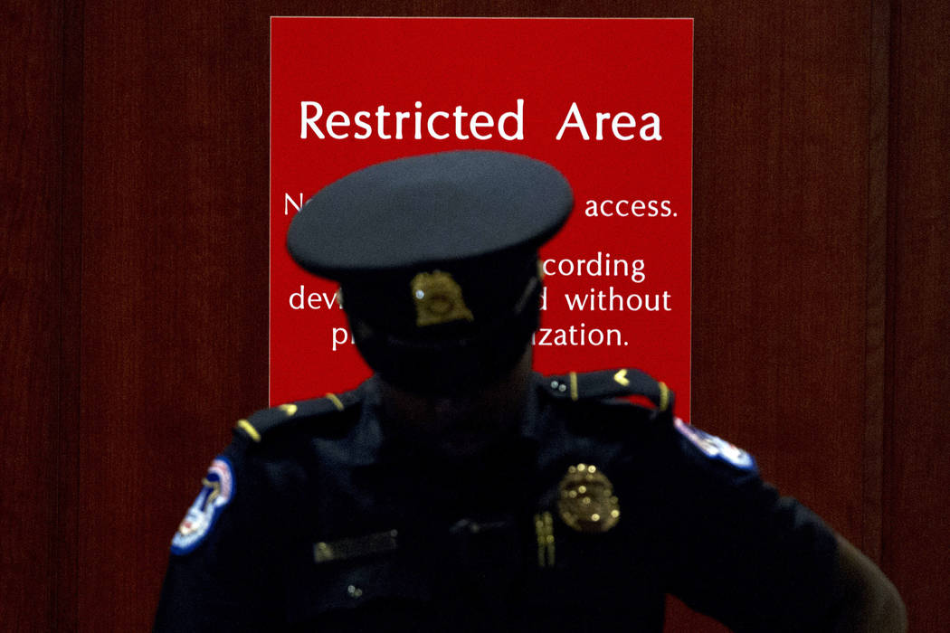 A U.S. Capitol Police officer stands at the entrance to a secure area during closed-door interv ...