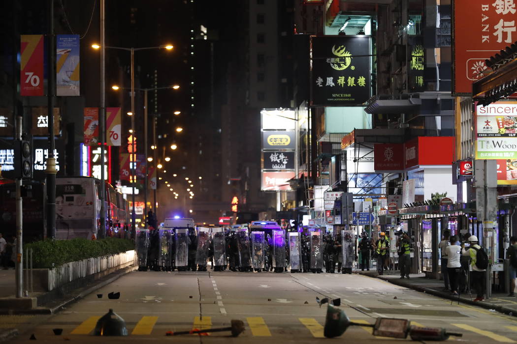 Rio policemen block a street in Hong Kong Friday, Oct. 4, 2019. Thousands of defiant masked pro ...