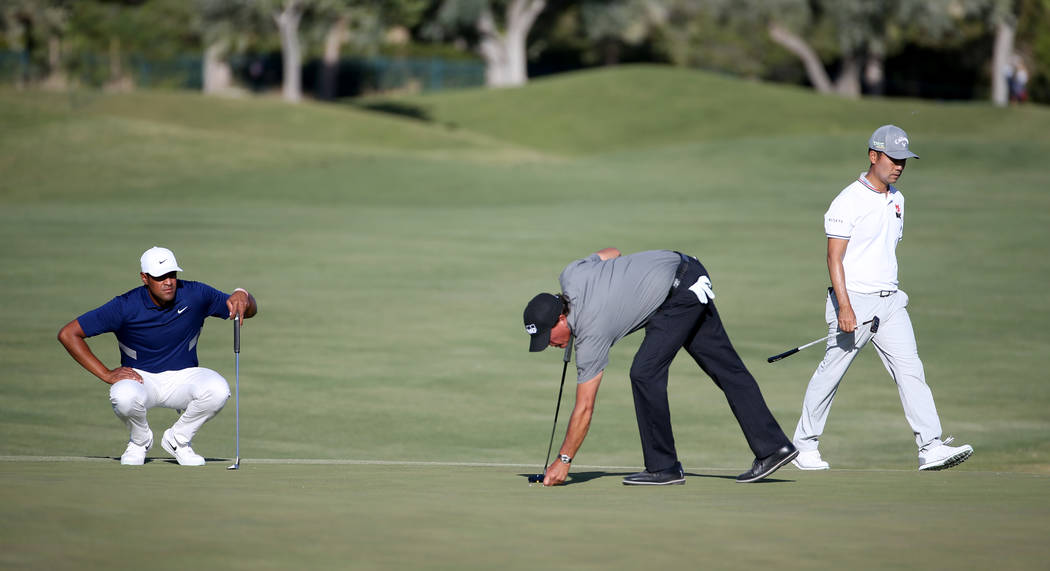 Tony Finau, from left, Phil Mickelson and Kevin Na prepare to putt on the 18th hole during seco ...