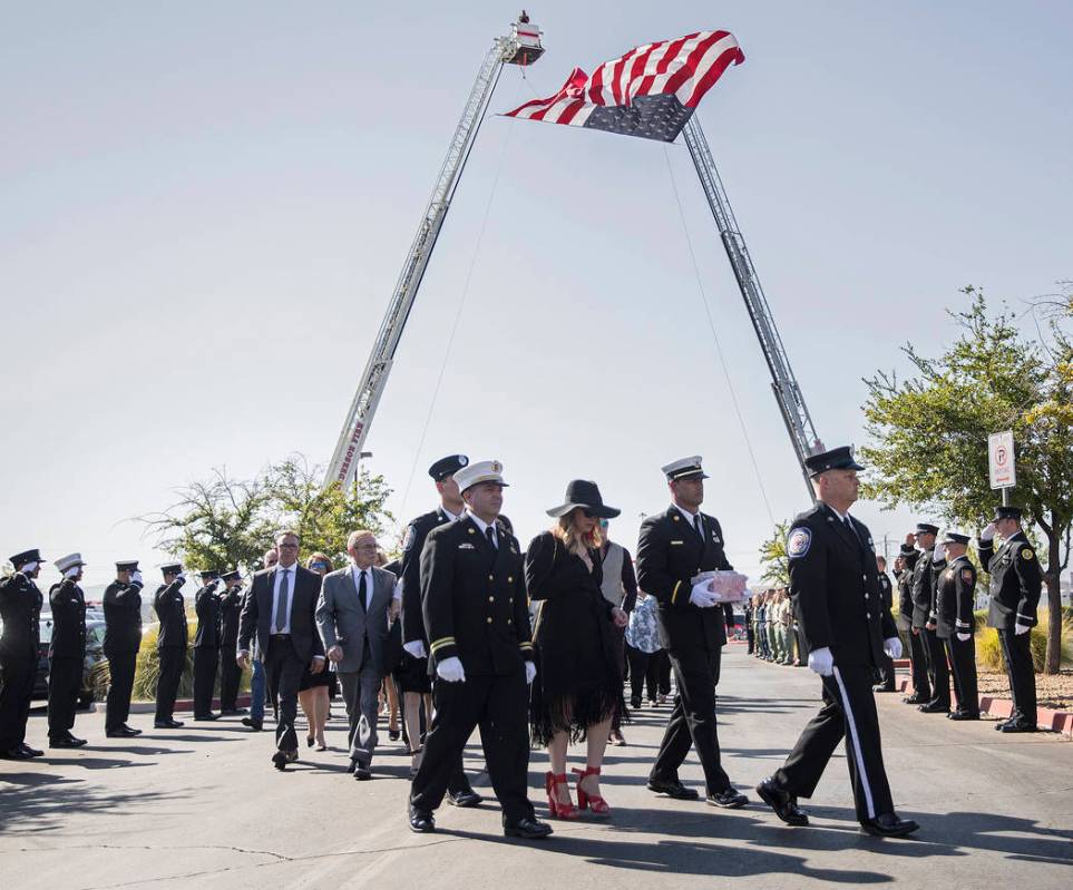 Henderson Fire Captain Garrett Dodrill, second from right, holds the urn containing the cremate ...