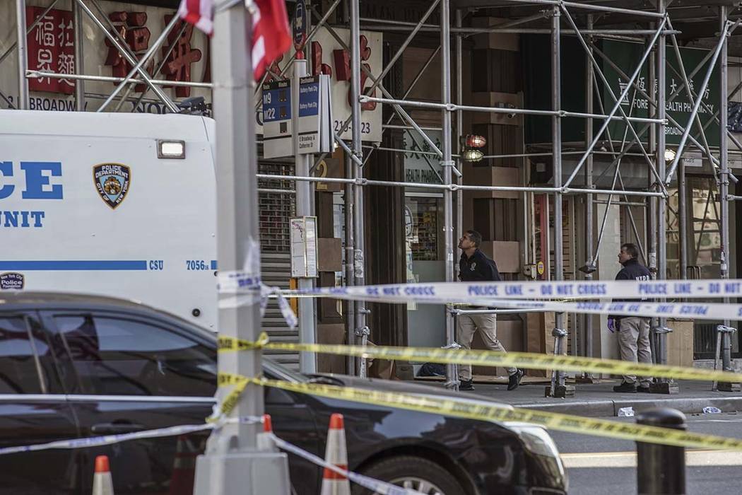 New York Police Department officers investigate the scene of an attack in Manhattan's Chinatown ...