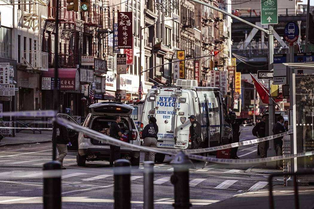 New York Police Department officers investigate the scene of an attack in Manhattan's Chinatown ...