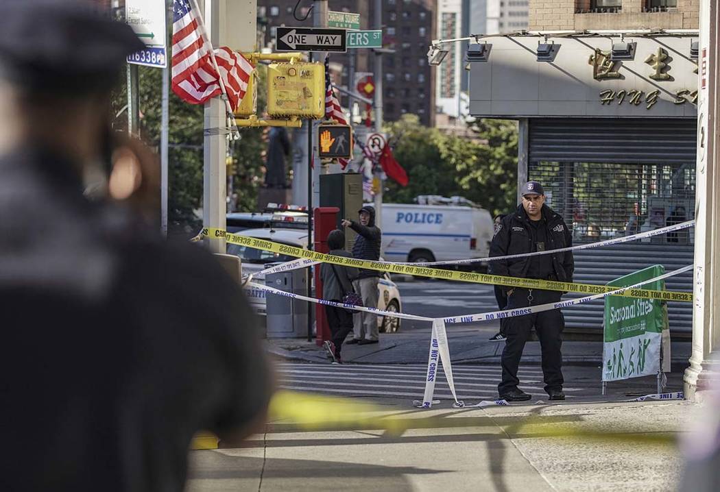 New York Police Department officers investigate the scene of an attack in Manhattan's Chinatown ...