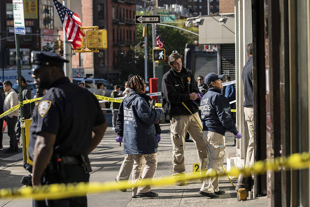 New York Police Department officers investigate the scene of an attack in Manhattan's Chinatown ...