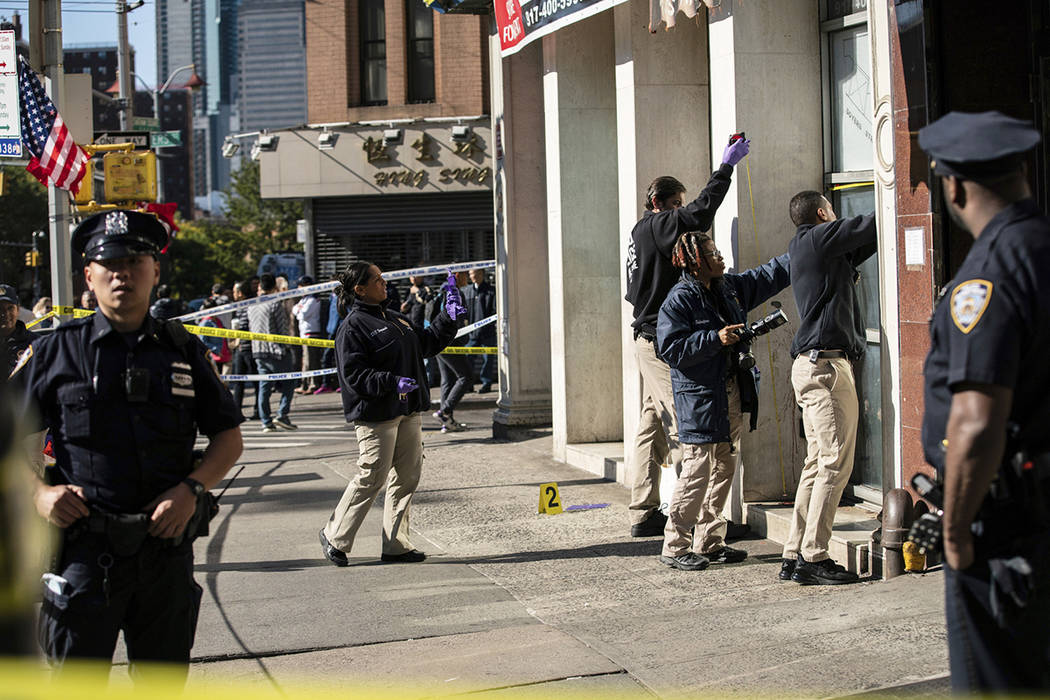 New York Police Department officers investigate the scene of an attack in Manhattan's Chinatown ...