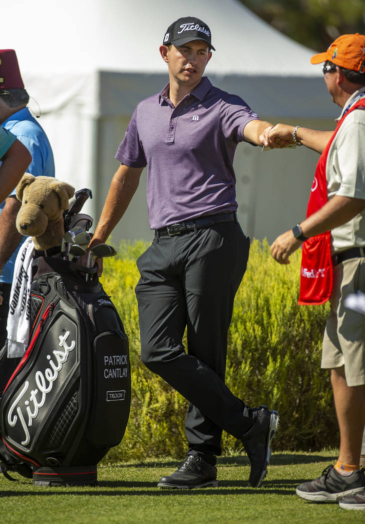 Patrick Cantlay greets a caddie as he waits to tee off on hole 1 during the third round of Shri ...